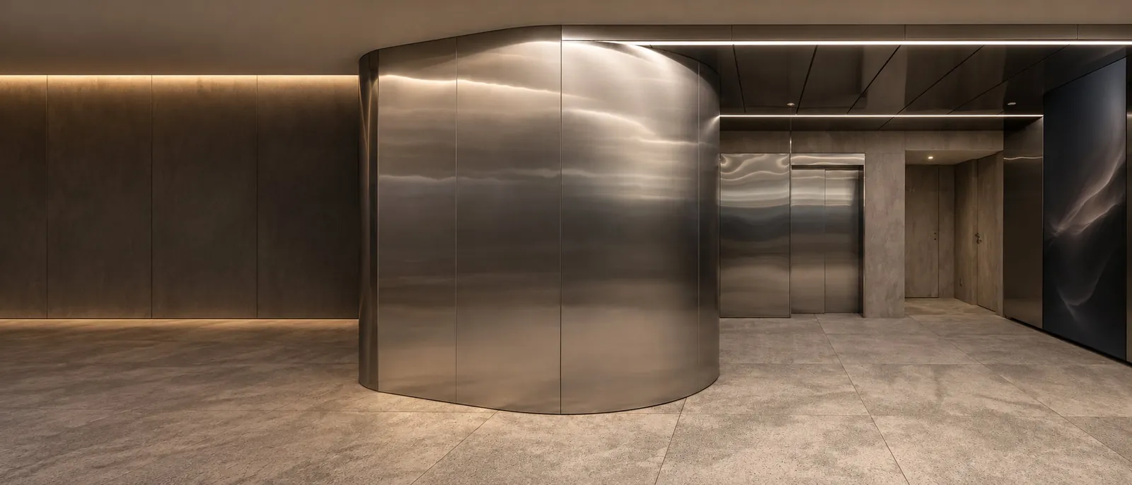 Curved brushed stainless steel cladding in an office lift lobby